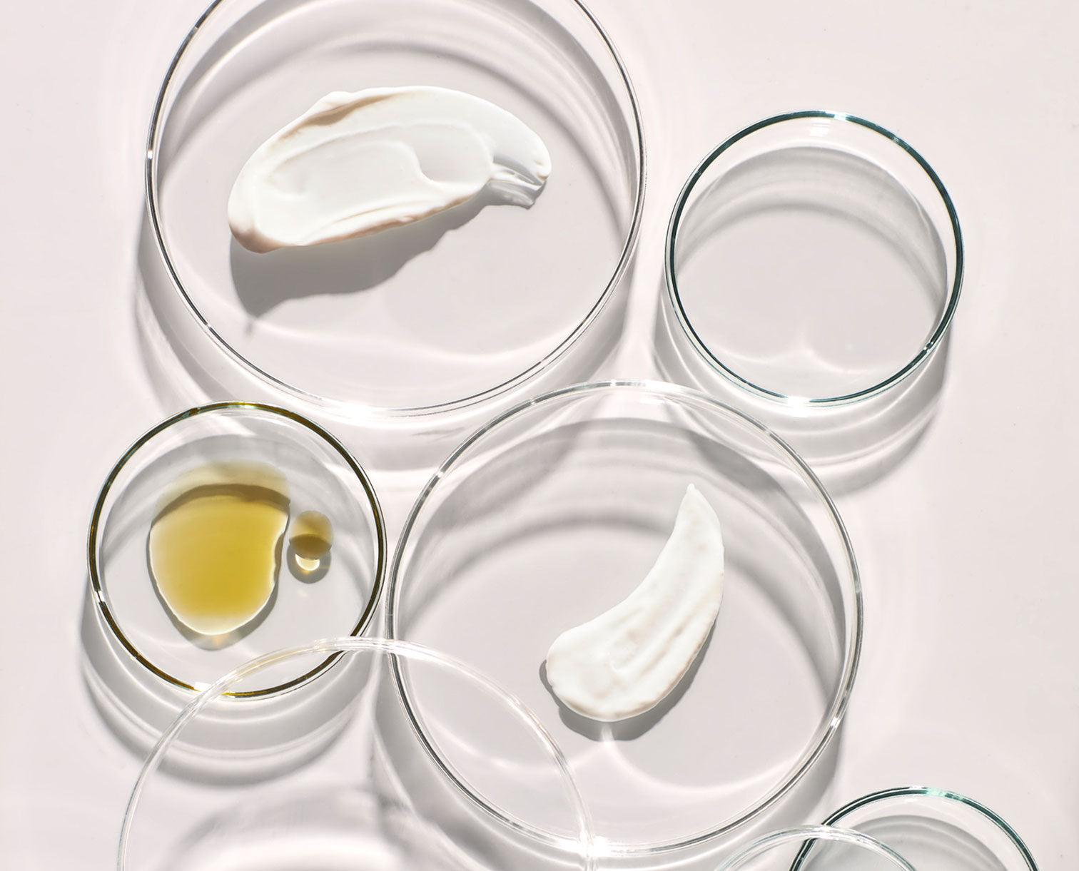 Image of Codex Beauty Labs product oil and cream textures displayed on various petri dishes