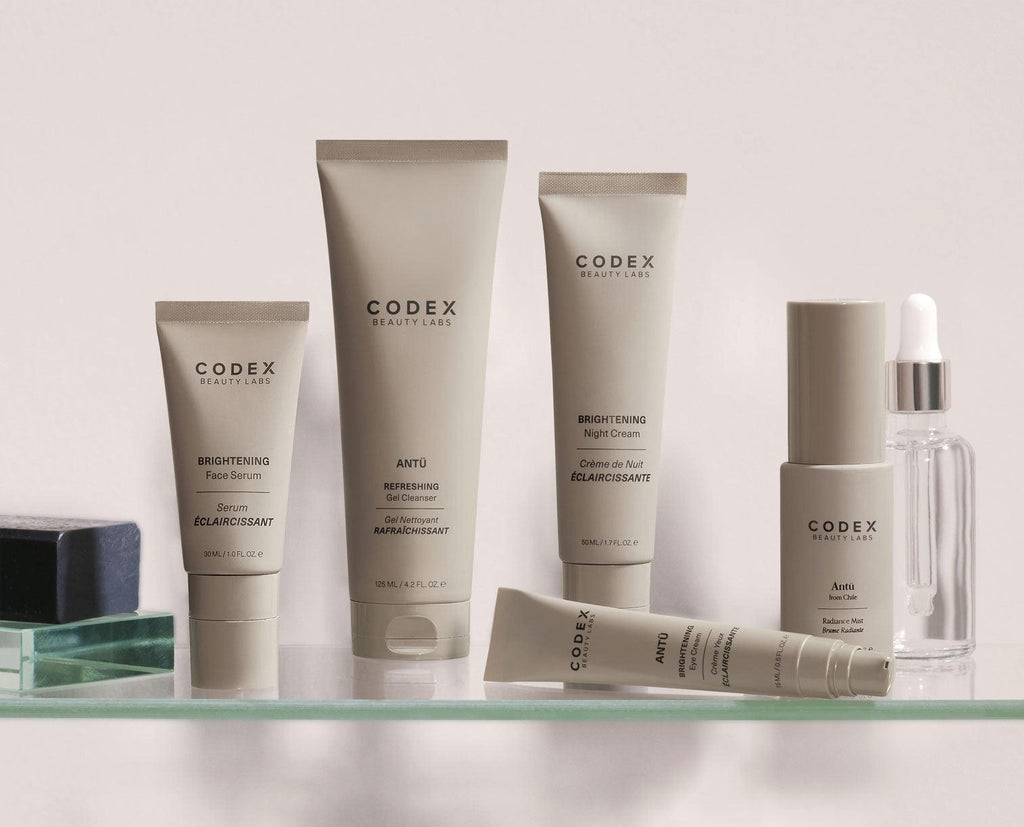 Image of the  range of Antu skincare bottles, placed on a glass bathroom shelf