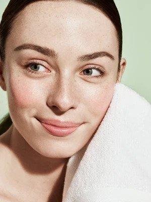 Codex Beauty Labs model using a towel to dry their face after applying a skin facial.