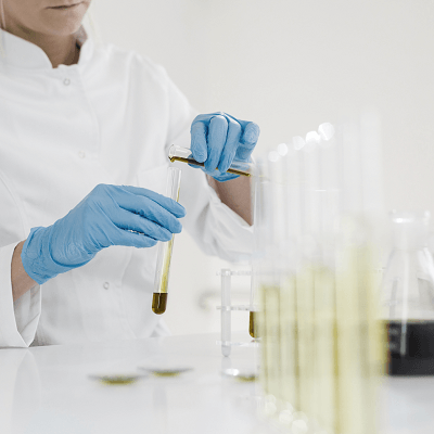 Image of a scientist putting chemicals in a flask.