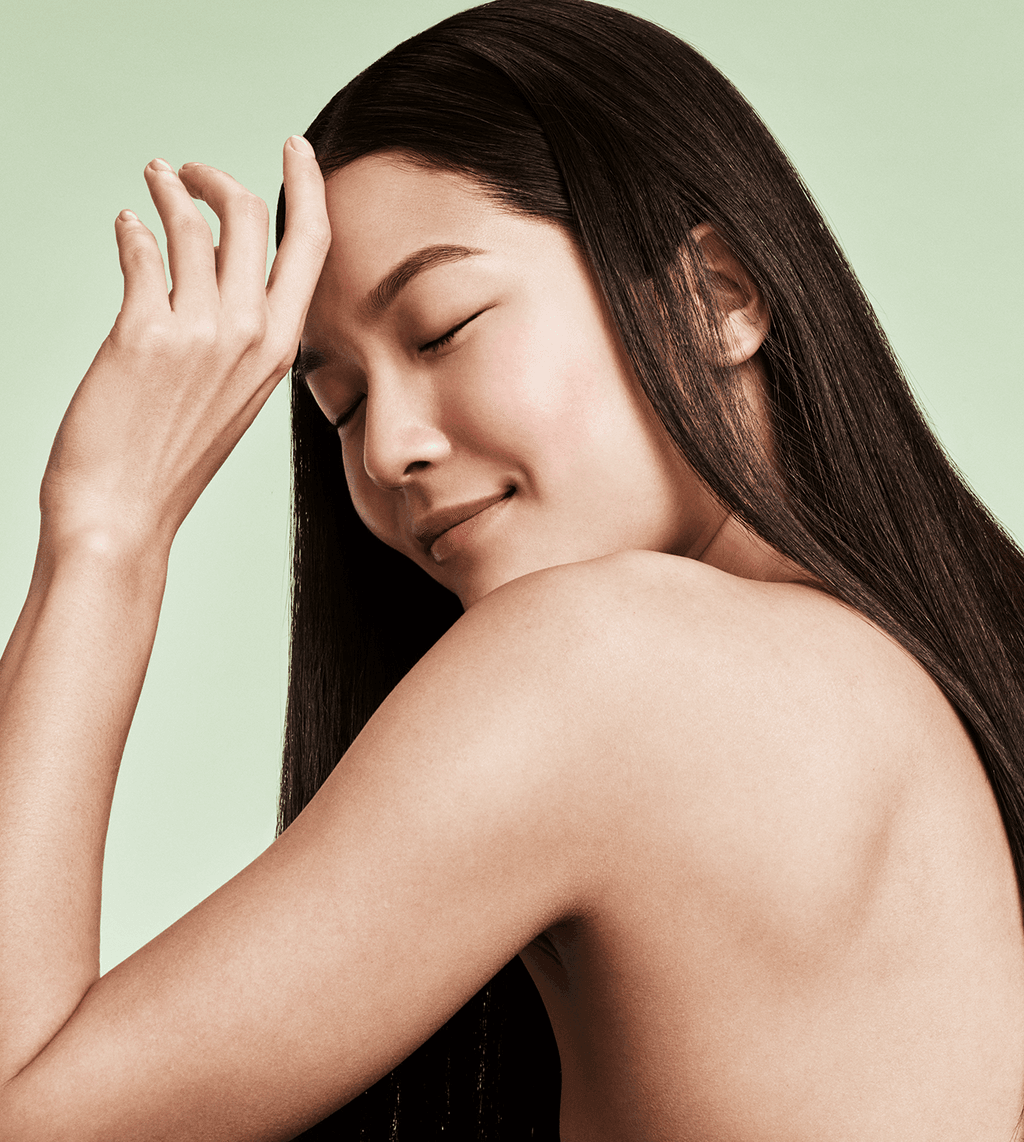 Image of a model looking off from the camera touching her head