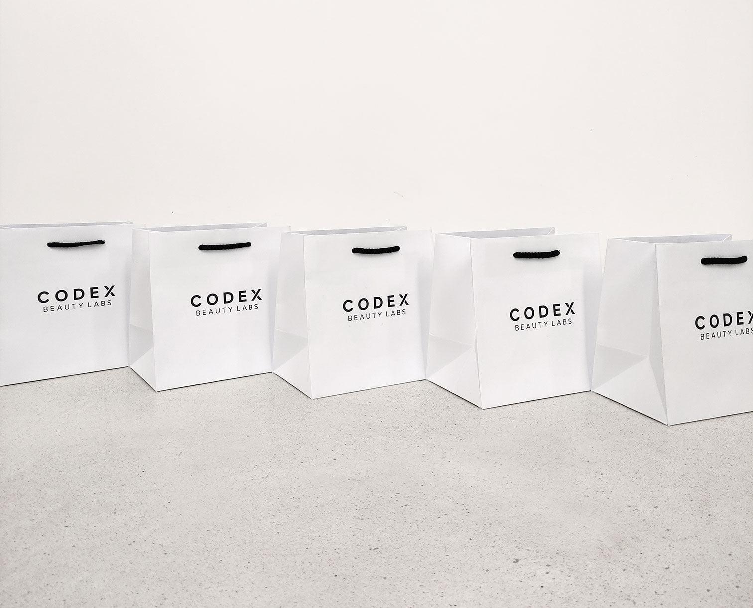 Image of Codex Beauty Labs gift bags arranged in a line on the floor 