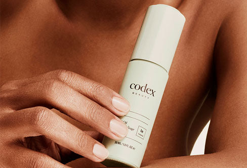 Image of a model holding a codex skin care product. 